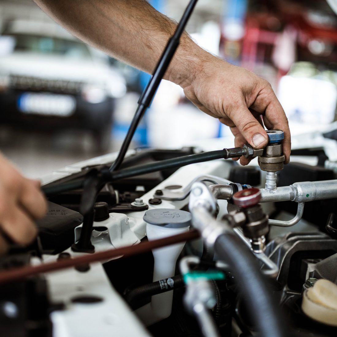Close up of unrecognizable mechanic charging AC in a car